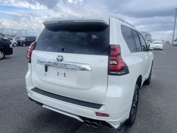 2022 Toyota Prado TXL in white, showcasing luxury SUV design at a car dealership in Bangladesh