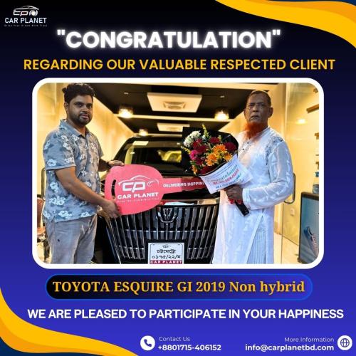 Car Planet congratulates a valuable customer on the purchase of a Toyota Esquire GI 2019 non-hybrid. Customer receives car key and bouquet in front of the vehicle. Car dealership in Bangladesh delivering happiness. Contact: +8801715-406152, info@carplanetbd.com.